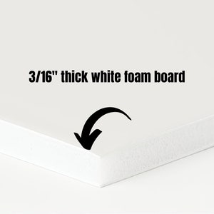 May include: A close-up of a white foam board, 3/16 inch thick. The board's edge is in focus, with a black arrow pointing towards it. The text "3/16" thick white foam board" is displayed in black.