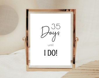 May include: A gold-framed sign with the text "35 Days until I DO!" on a white background.