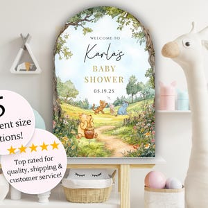 May include: A Winnie the Pooh themed baby shower welcome sign with a whimsical illustration of Winnie the Pooh and his friends in a forest setting. The sign is personalized with the name "Karla's" and the date "05.19.25".