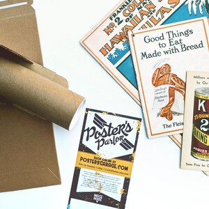May include: A collection of vintage-style prints and ephemera, including a poster from "Poster's Parlor" and advertisements for baking powder and bread. The items are arranged on a white surface, with a brown cardboard shipping tube and box visible.