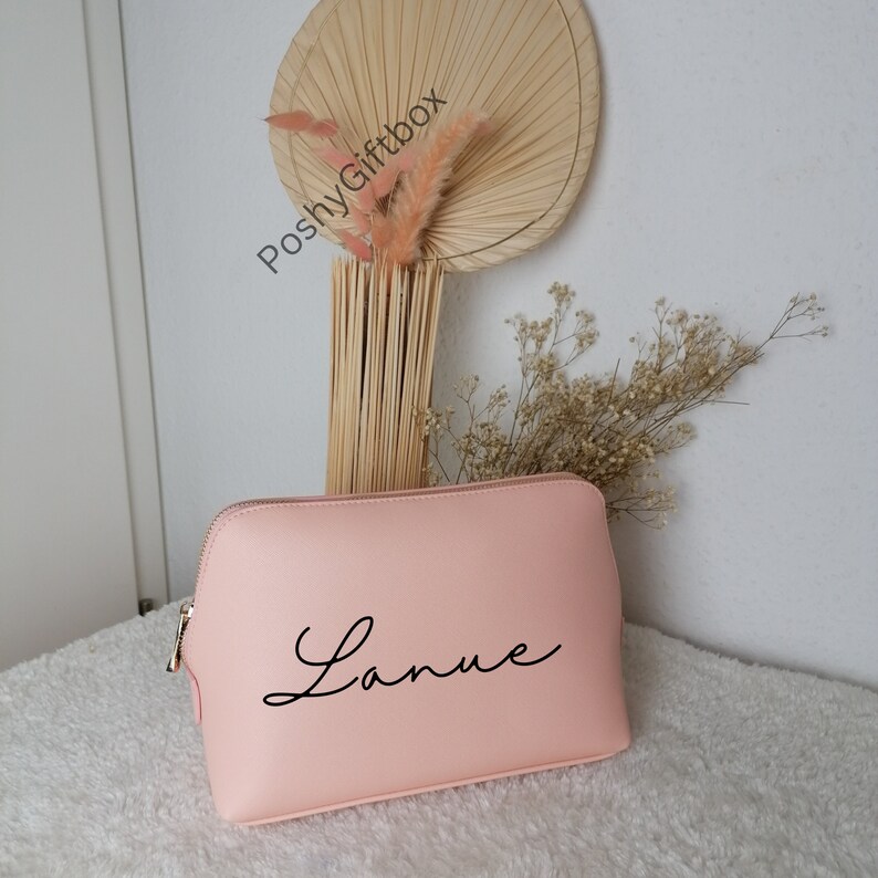May include: A light pink zippered makeup bag with the name "Lanie" written in black cursive script.
