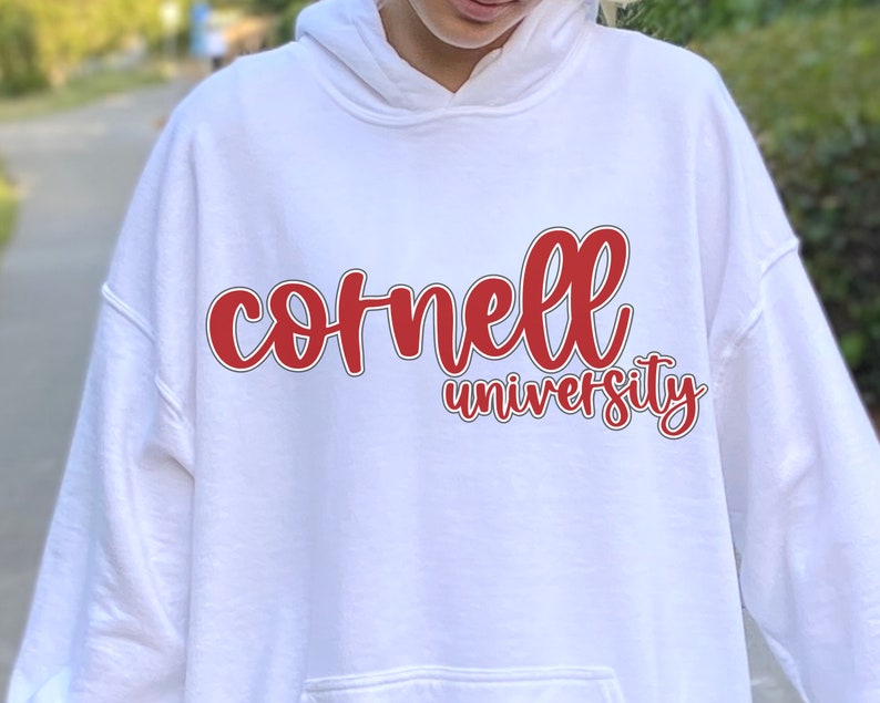 May include: White hooded sweatshirt with a red and black graphic that says "Cornell University" in a cursive font.