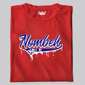 May include: Red t-shirt with a blue and white graphic that says "Nombeh" with dripping paint. The brand name "Cabal" is printed on the shirt.
