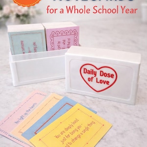 Op de afbeelding: Een set positieve affirmatie notecards voor een heel schooljaar. De kaarten zitten in een witte doos met een rood hart met de tekst "Daily Dose of Love". De afbeelding bevat de tekst "200 kaarten!" en "+ Opbeurende berichten voor elke schooldag!"