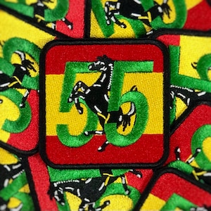 May include: Embroidered patch with a black horse and the number 56 in green, yellow, and red. The patch has a square shape with rounded corners and a black border. The horse is rearing up on its hind legs.