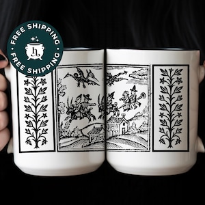 Peut inclure: Deux mugs en céramique blanche avec des illustrations noires d'une scène de sorcière vintage. Les mugs ont un bord et des anses noirs. Les mugs sont décorés d'un motif floral noir et blanc sur les côtés. Les mugs sont tenus par une personne.