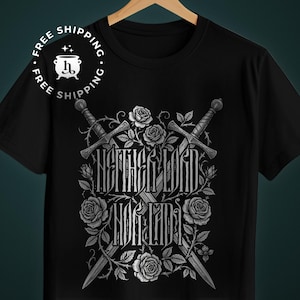 May include: Black t-shirt with a detailed graphic. The design features two crossed swords, roses, and the text "HERITAGE LORD NOR LADY" in a decorative font, in shades of grey and white.