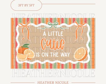 以下が含まれることがあります： オレンジ色のスクリプトで「A Little Cutie Is On The Way」と書かれた長方形の看板。オレンジのスライスとリボンが特徴で、オレンジ、緑、赤のストライプの背景があります。看板のサイズは91cm×152cmです。