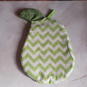 May include: A pear-shaped kitchen pot holder with a green and white chevron pattern. The pot holder has a green leaf attached at the top. The pot holder is made of fabric.
