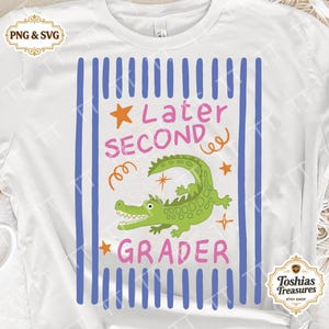 Könnte beinhalten: Weißes T-Shirt mit einer Grafik, die ein grünes Alligator zeigt und die Worte "Later Second Grader" in Pink und Orange. Blaue vertikale Streifen umrahmen das Design, mit orangefarbenen Sternen und Wirbeln. Das T-Shirt hat einen Rundhalsausschnitt.
