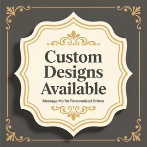 May include: A decorative sign with a cream-coloured, ornate frame and the words "Custom Designs Available" in dark text. The sign also includes the text "Message Me for Personalized Orders". The background is dark grey.