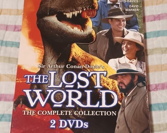 May include: DVD box set of the classic adventure series "The Lost World" by Sir Arthur Conan Doyle. The box features a red and yellow background with a dinosaur illustration and the title in bold white letters. The box also includes the names of the actors in the series, Eric McCormack, John Rhys-Davies, and David Warner.