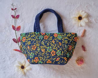 Bolsa de mão com alça superior bordada com flores e miçangas