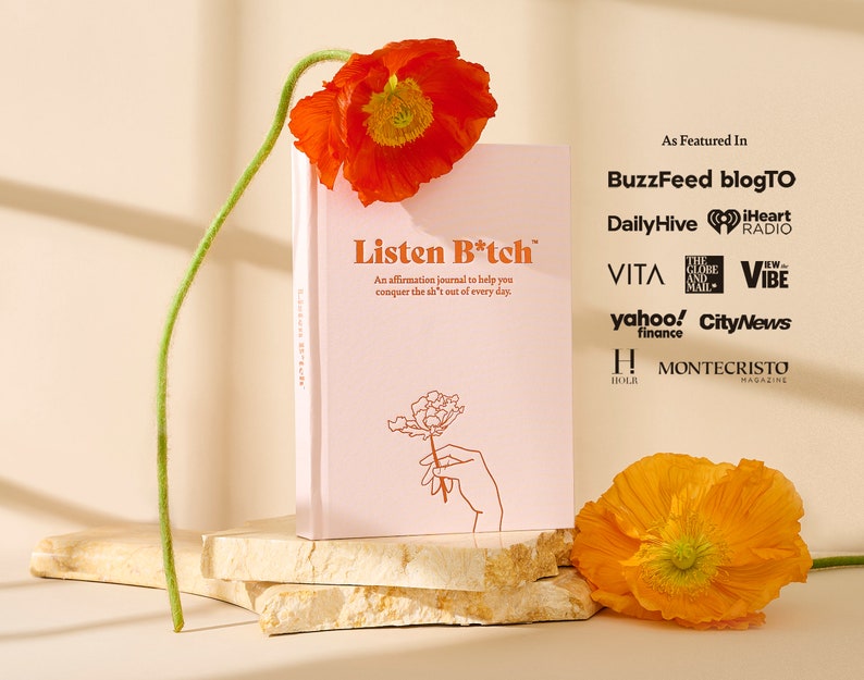 May include: A pink journal with the title "Listen B*tch" and a floral illustration. The journal is on a stack of beige stone coasters. The text "As Featured In" is above a list of publications and media outlets.