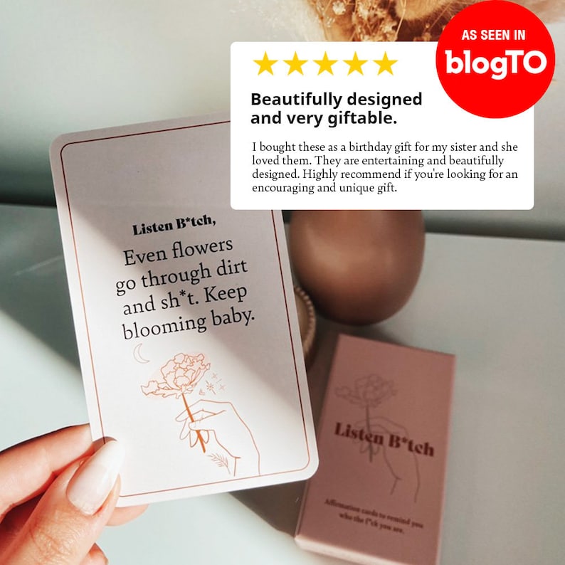 Puede incluir: Un juego de cartas de afirmaci&oacute;n con un fondo rosa y una ilustraci&oacute;n en blanco y negro de una mano sosteniendo una flor. El texto en la tarjeta dice "Listen B*tch, Even flowers go through dirt and sh*t. Keep blooming baby."