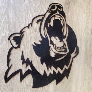 May include: Black metal silhouette of a bear's head with its mouth open in a roar. The bear's teeth are visible.