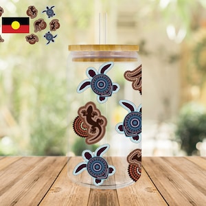 May include: A clear glass tumbler with a bamboo lid and a straw. The tumbler is decorated with a pattern of turtles, lizards, and circles in shades of brown, blue, and white.