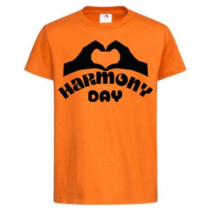 May include: Orange t-shirt with black text that reads "Harmony Day" and a black silhouette of two hands making a heart shape.