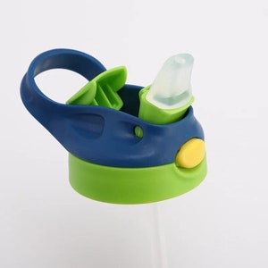 May include: A blue and green water bottle lid with a yellow button and a clear silicone spout. The lid has a carrying handle and a flip-top lid.