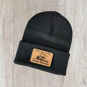 May include: Black beanie with a brown leather patch that says "Take 'em to the Train Station" with a cartoon train on it.
