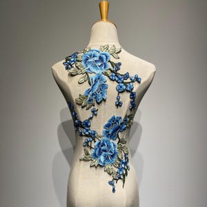 衣服の背面やアメリカ風デニムジャケットに使える、ブルーの繊細な刺繍の花の縫い付けパッチ。DIY作品に最適な、時代を超えた花の美しさ。