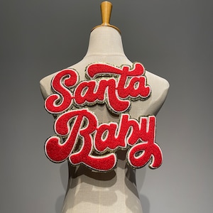 May include: A white mannequin with a red felt patch that says "Santa Baby" in a retro font.