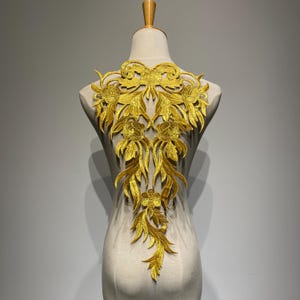 Könnte beinhalten: Goldene Blumenapplikation mit einem zarten Design, perfekt um Kleidung oder Bastelarbeiten einen Hauch von Eleganz zu verleihen.