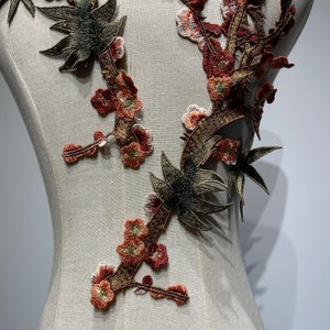 May include: A brown and green floral applique with a delicate design. The applique features small flowers and leaves, and is perfect for adding a touch of elegance to any project.