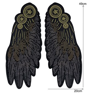 May include: A pair of black fabric wings with gold embroidered details. The wings are 49 cm tall and 20 cm wide.