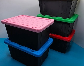 May include: A stack of black storage bins with colorful lids. The lids are in yellow, green, red, pink, and blue. The bins are rectangular and have a textured surface.