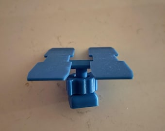 May include: A blue plastic component with a central threaded adjustment and two rectangular wings. The component is designed for mechanical use and is set against a neutral background.