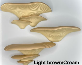 May include: Light brown and cream-colored mushroom sculptures. The sculptures have a layered, fan-like design with detailed, textured surfaces. The text "Light brown/Cream" is visible in the image.