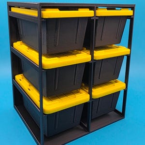 May include: A black storage unit featuring six black storage boxes, each with a bright yellow lid. The boxes are arranged in two columns of three, within a robust black frame. The background is a solid light blue.