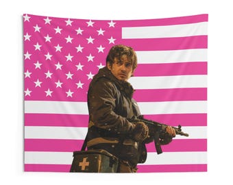 May include: A rectangular wall tapestry featuring a pink and white American flag pattern. In the center, a person in a dark jacket holds a black firearm and carries a dark medical bag with a white cross symbol printed on the front surface.