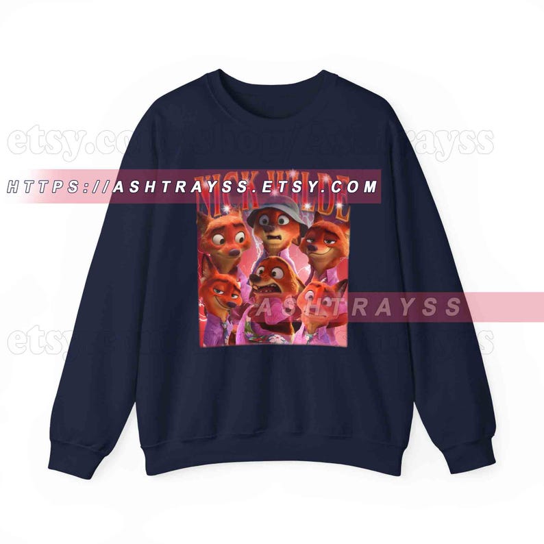 Puede incluir: Sudadera azul marino con un estampado gr&aacute;fico de zorros de dibujos animados y el texto "NICK WILDE". El dise&ntilde;o presenta varios zorros en diferentes poses, sobre un fondo rosa, en un estilo retro.