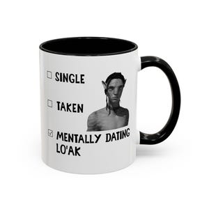 Könnte beinhalten: Eine weiße Keramiktasse mit schwarzem Innenraum und Griff. Die Tasse zeigt den Text "SINGLE", "TAKEN" und "MENTALLY DATING LO'AK" mit einem Häkchen neben der letzten Option. Ein Bild einer Figur aus dem Film Avatar befindet sich ebenfalls auf der Tasse.
