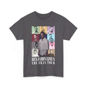 Puede incluir: Una camiseta gris oscuro con un collage colorido de la cara de un hombre en diferentes poses. El texto "BENJAMIN LINUS THE ERAS TOUR" está impreso en blanco debajo del collage.