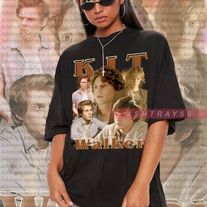 Może przedstawiać: Czarny t-shirt unisex z kolażem zdjęć i słowem "KIT" w brązowej, vintage czcionce. Słowo "Walker" znajduje się poniżej. Modelka nosi rozmiar 2XL.