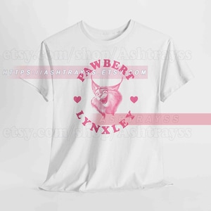 May include: White t-shirt with a pink cartoon lynx design and the words "PAWBERRY LYNXLE". The design includes pink hearts. The Etsy shop URL is visible at the top and bottom of the image.