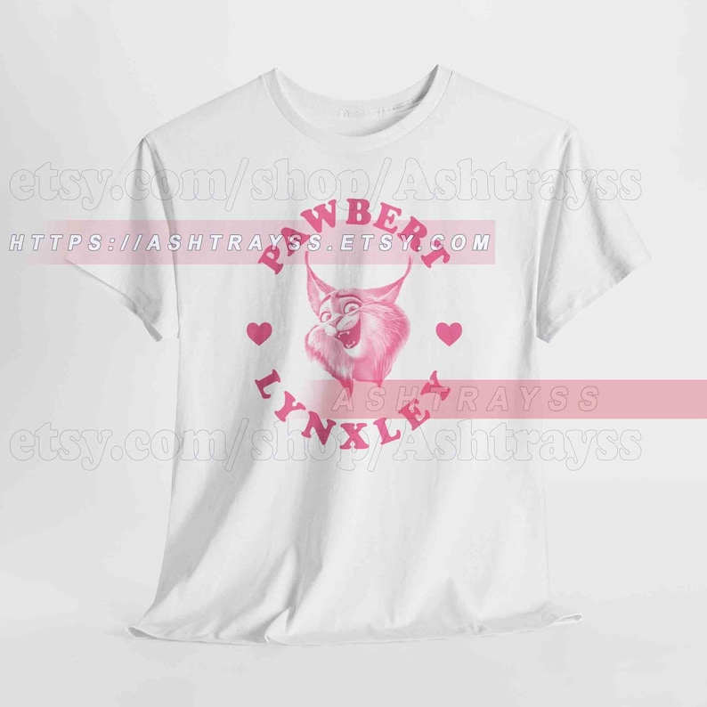 May include: White t-shirt with a pink cartoon lynx design and the words "PAWBERRY LYNXLE". The design includes pink hearts. The Etsy shop URL is visible at the top and bottom of the image.