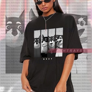May include: Black unisex t-shirt featuring a graphic of four dogs in black and white. The word "BEEF" is printed below the dogs. The shirt is oversized and made of a soft material.