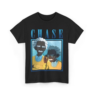 May include: Black t-shirt featuring a cartoon illustration of two older men with white hair and mustaches. The men are wearing yellow sweaters and glasses. The word "CHASE" is printed in blue above the illustration.