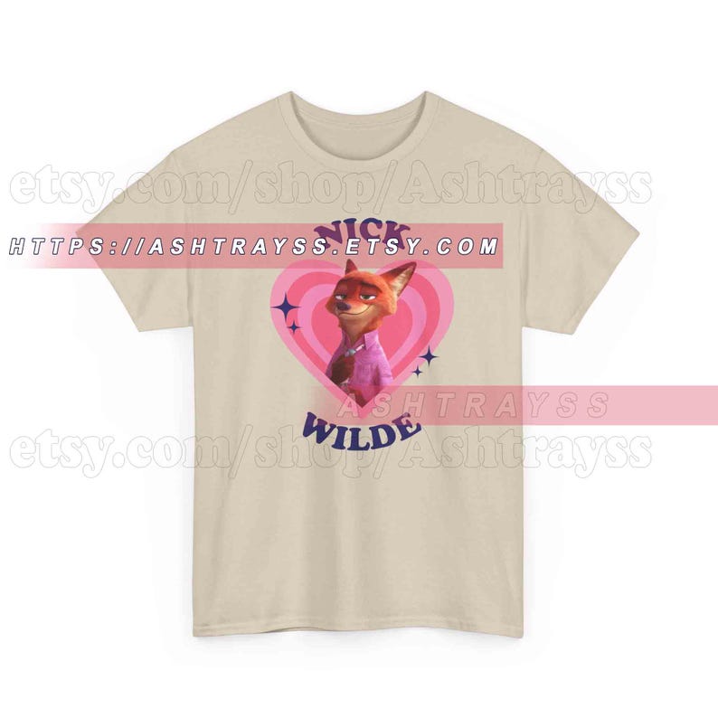 May include: A beige t-shirt featuring a cartoon image of Nick Wilde from Zootopia inside a pink heart. The text "Nick Wilde" is above the image, and "Wilde" is below. The shirt also has the Etsy shop URL.