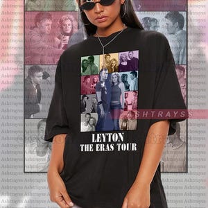 May include: A black t-shirt with a collage of photos of a couple. The photos are arranged in a grid pattern and are in various colors. The text "LEYTON THE ERAS TOUR" is printed in white below the photos.