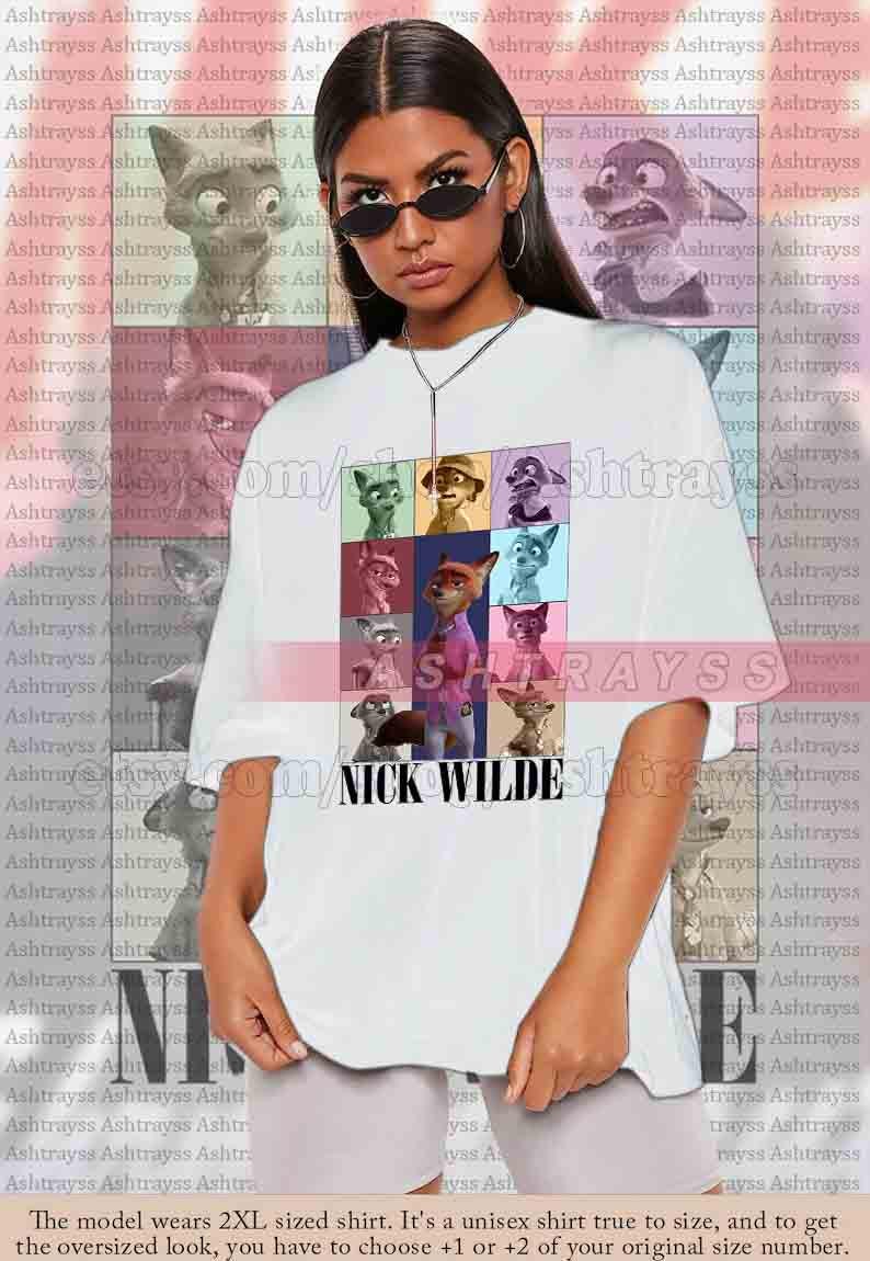 Peut inclure: T-shirt unisexe blanc avec une grille color&eacute;e de personnages de dessins anim&eacute;s et le texte "NICK WILDE". Le t-shirt a des manches courtes et une coupe d&eacute;contract&eacute;e, id&eacute;al pour un usage quotidien.