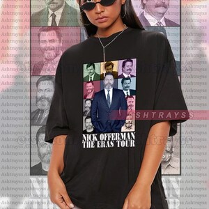 May include: Black unisex t-shirt with a graphic of Nick Offerman and the text "NICK OFFERMAN THE ERAS TOUR." The design includes multiple images of the actor. The model is wearing a 2XL shirt.