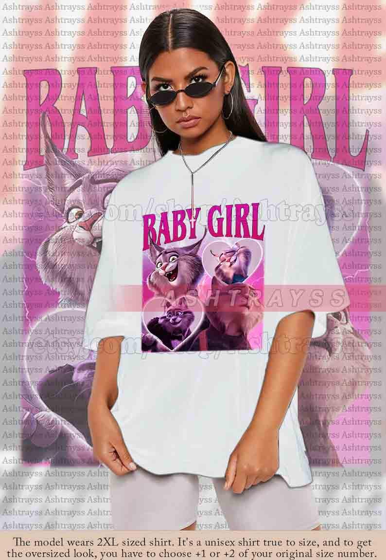 May include: White unisex t-shirt featuring the text "BABY GIRL" in pink, with cartoon cat graphics. The model is wearing a 2XL shirt. The shirt is true to size, and for an oversized look, choose +1 or +2 sizes.