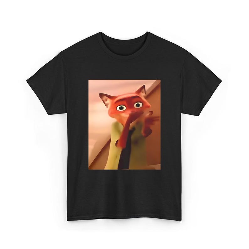 May include: Black t-shirt featuring a cartoon image of Nick Wilde from the movie Zootopia. The image shows Nick with a surprised expression, wearing a green shirt and red tie. The shirt is a classic crew neck style.