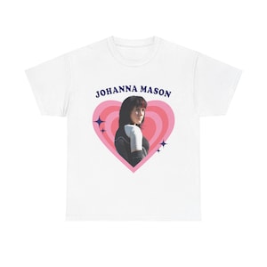 Könnte beinhalten: Ein weißes Kurzarm-T-Shirt mit einer Grafik einer Person mit dunklen Haaren in einem schwarz-weißen Sportoberteil. Die Grafik ist von einem rosa Herz mit konzentrischen Ringen und dunkelblauen Sternakzenten umrahmt, darüber steht JOHANNA MASON.