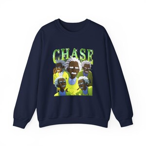 May include: A navy blue sweatshirt with a cartoon illustration of a man with white hair and a mustache, repeated. The word "CHASE" is printed in green, with a white outline, above the illustration.